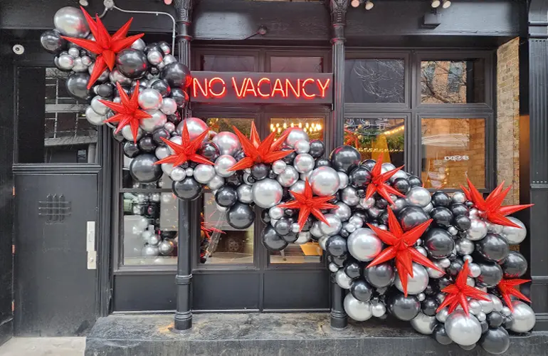 Organic balloon garland with foil balloon spikes on the outside of a business for their grand opening event.