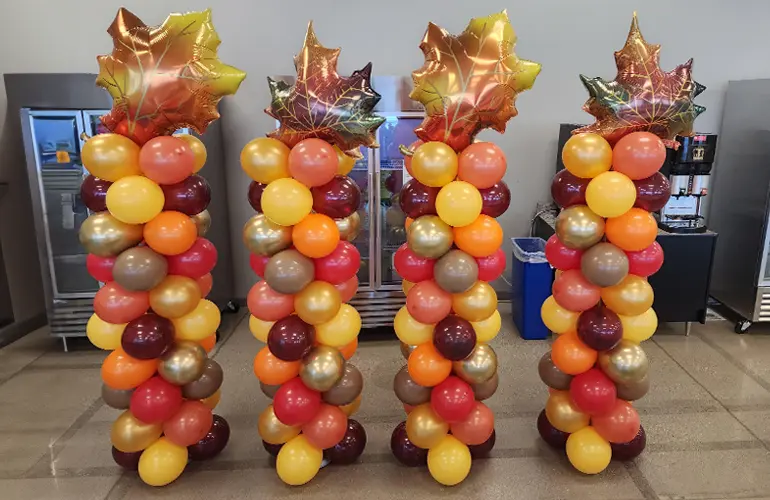 Balloon columns in autumn colors with foil leaf shape topper