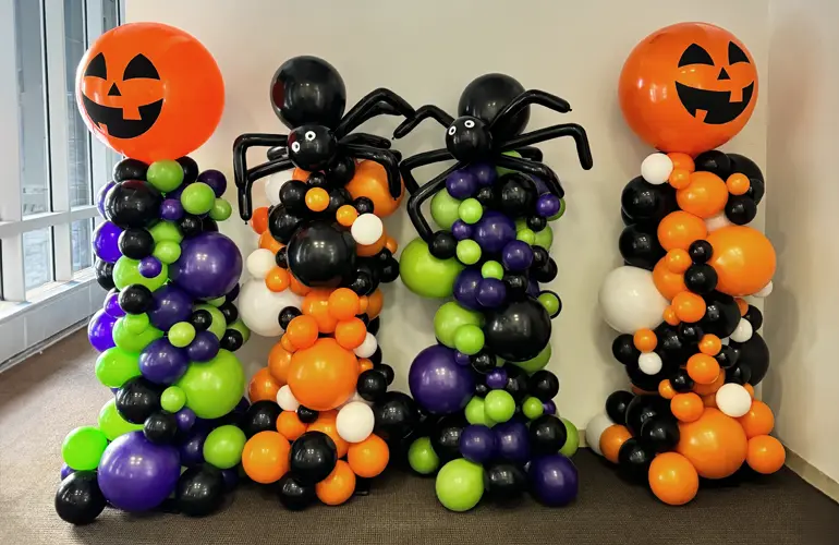 Organic balloon columns with pumpkins and spiders for office Halloween party