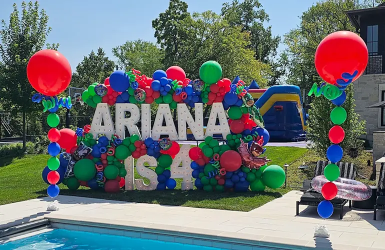 Organic balloon garland set up on Alpha-Lit letters poolside