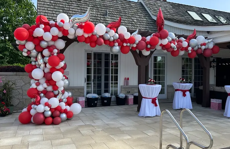 Organic balloon garland set up in backyard for a milestone celebration