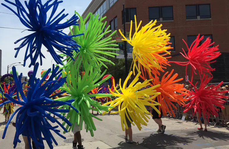 Rainbow balloon firework backpacks and carrying poles in the Chicago Pride Parade