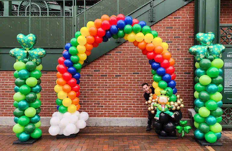 St Patrick's Day themed balloon columns with a pot of gold rainbow arch