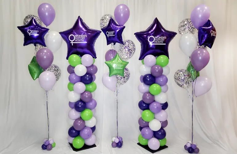 Classic balloon columns and sparkly balloon bouquets with the Women's History Month logo