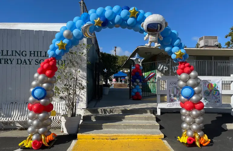 Space themed balloon arch with rockets and astronaut