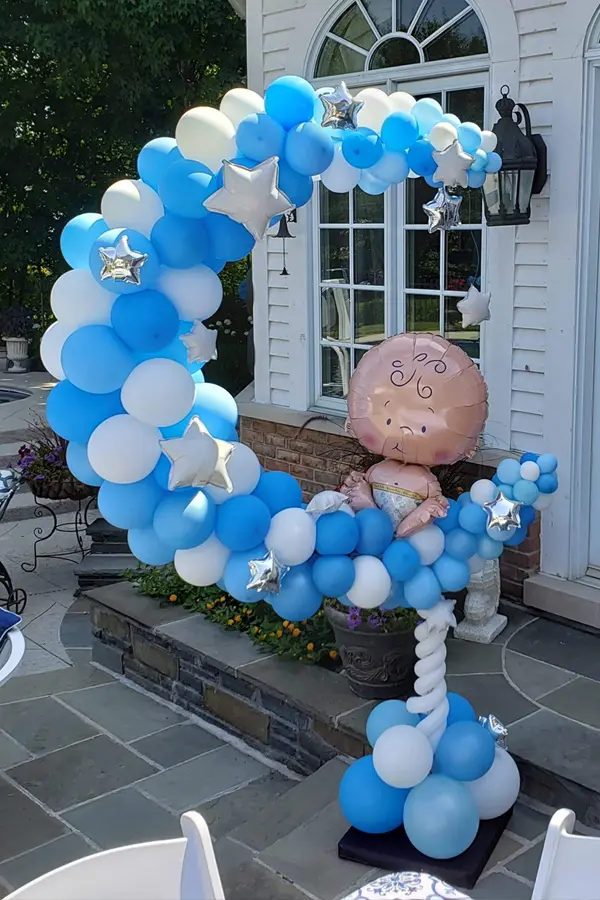 Balloon sculpture of a moon with a foil baby balloon accent