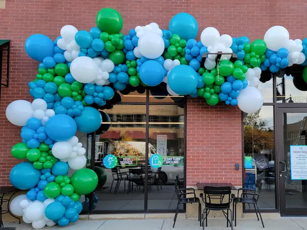 Organic balloon garland shown covering the outside of a building