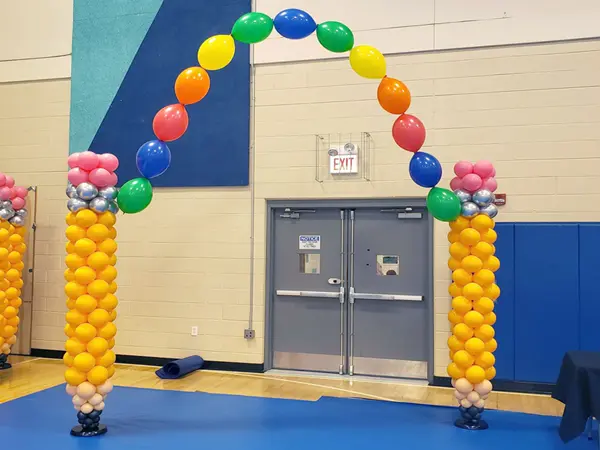 Pencil balloon sculptures creating a balloon arch with helium balloons attached