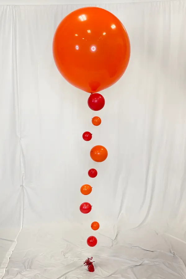 Single helium filled jumbo balloon with smaller balloons attached to look like bubbles