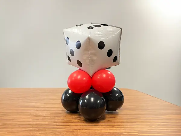 Mini balloon centerpiece with a foil dice shaped topper