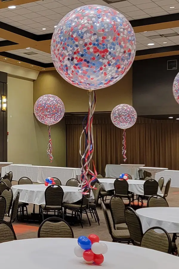 Confetti inside of a jumbo balloon creating a table centerpiece that fills the room with color
