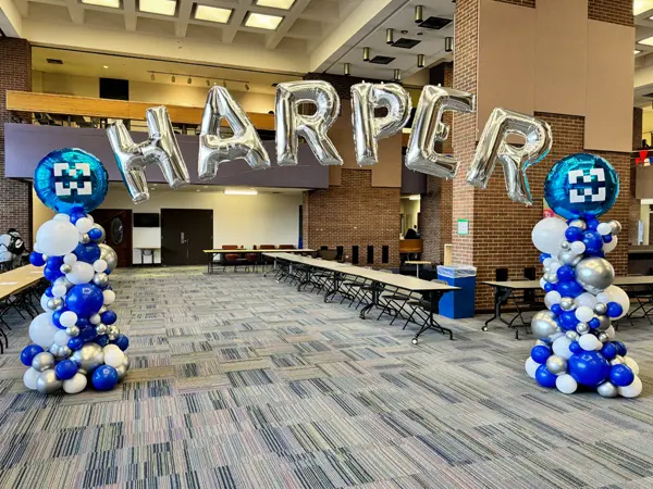 Organic columns with HARPER foil balloon letters creating a custom indoor balloon arch