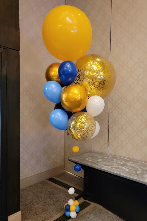 Balloon bouquet of varying sizes with glitter and foil orb accents standing 10ft tall