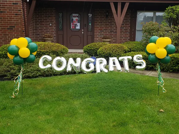 Outdoor balloon decor spelling out congrats