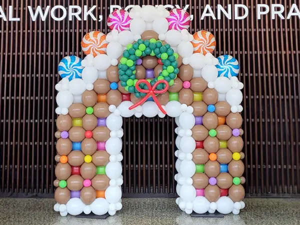 A balloon gingerbread house photo op and room decoration display