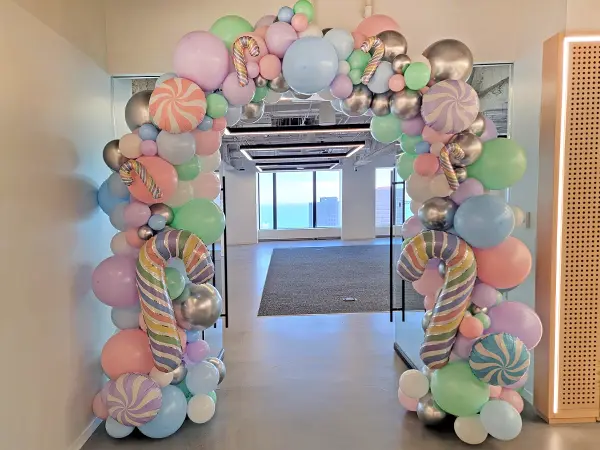Pastel colored organic balloon arch with pastel candy cane accents