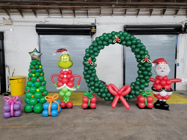Balloon display or photo op area of a Wreath house with Santa, Mr Grinch, a Christmas Tree and gifts