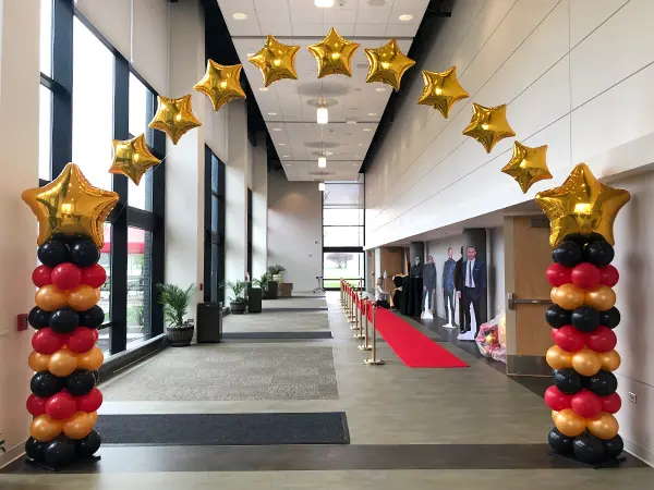 Balloon columns with foil stars strung in between creating an arch