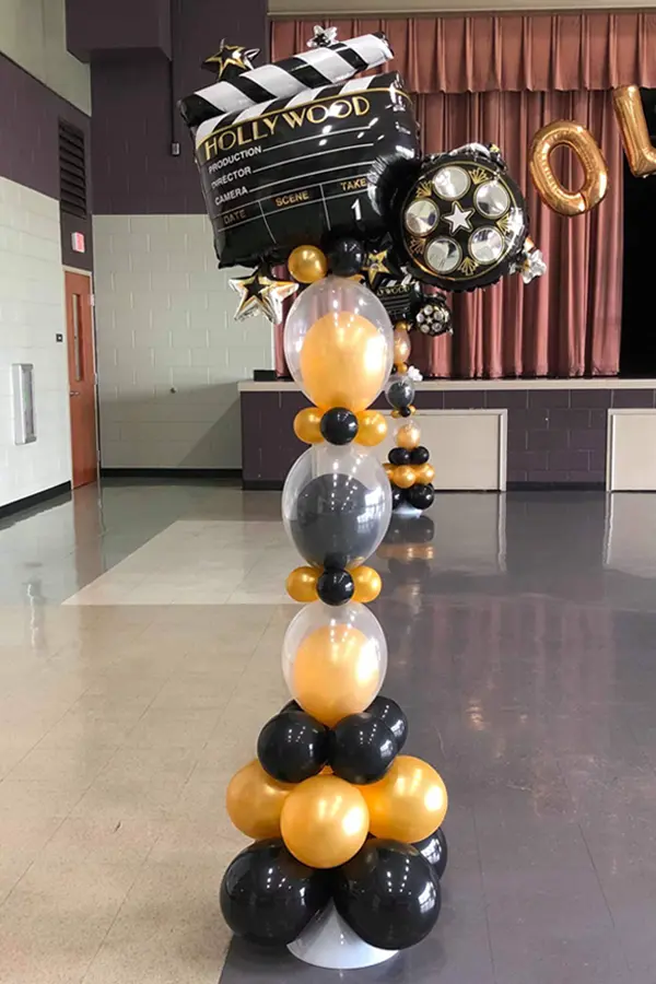 Skinny column topped with Hollywood themed balloon foil