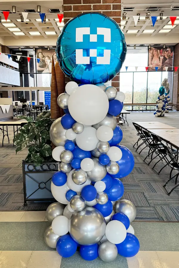 7.5ft tall organic balloon column with logo on a jumbo round balloon topper