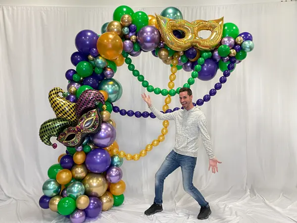 Trendy alternative to a classic balloon arch decorated with foil masks and balloon bead swags