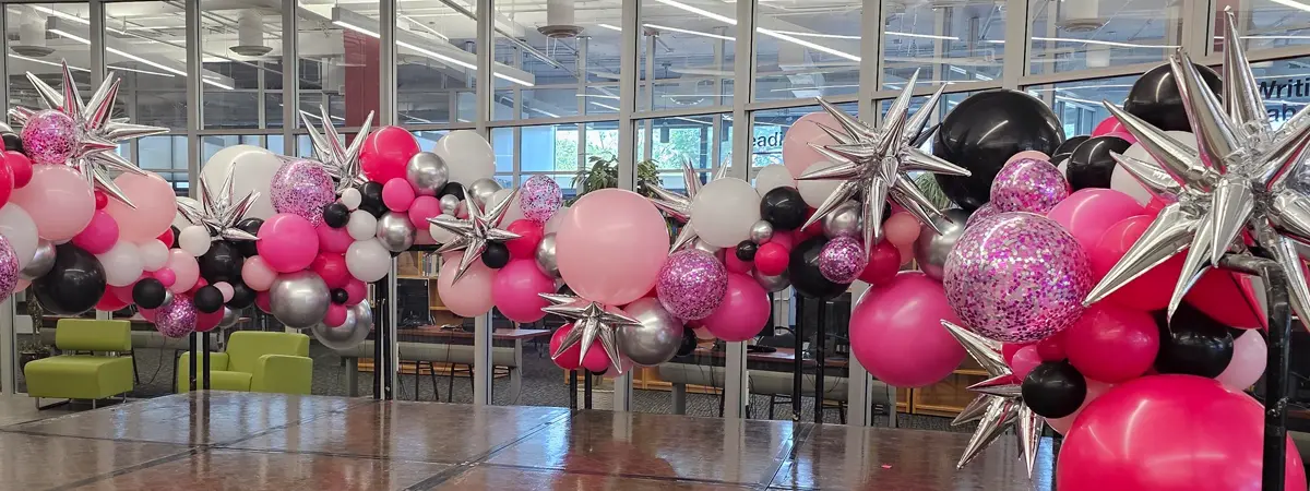 Customized organic balloon garland in pink and black balloons with glitter and starburst add-ons