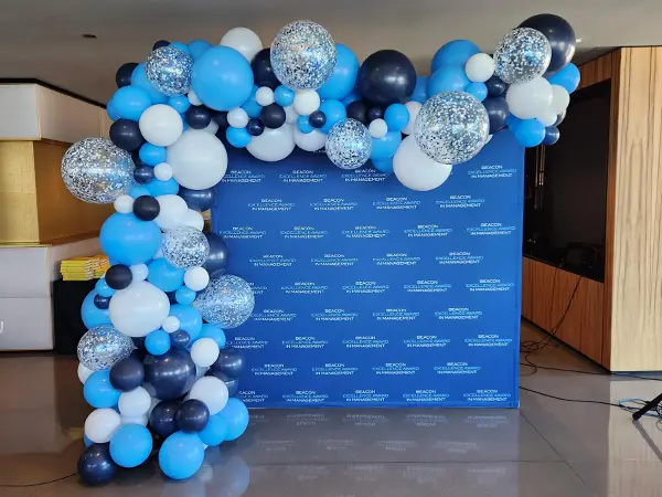 A freestanding balloon wave accented with glitter balloons to create a fashionable alternative to the classic look of balloon arch