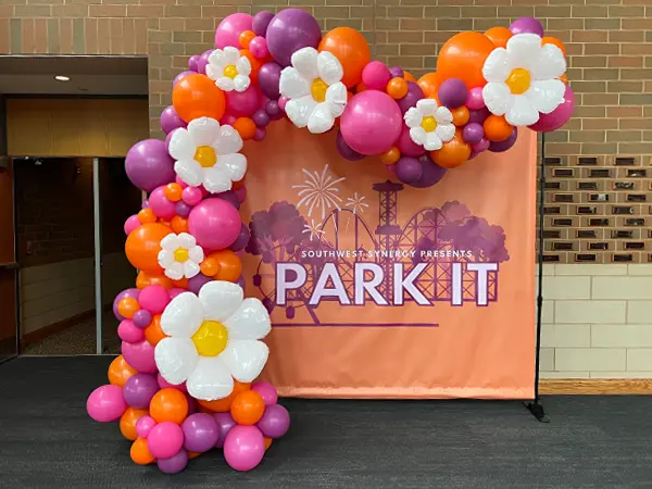 A freestanding balloon wave accented with glitter balloons to create a fashionable alternative to the classic look of balloon arch