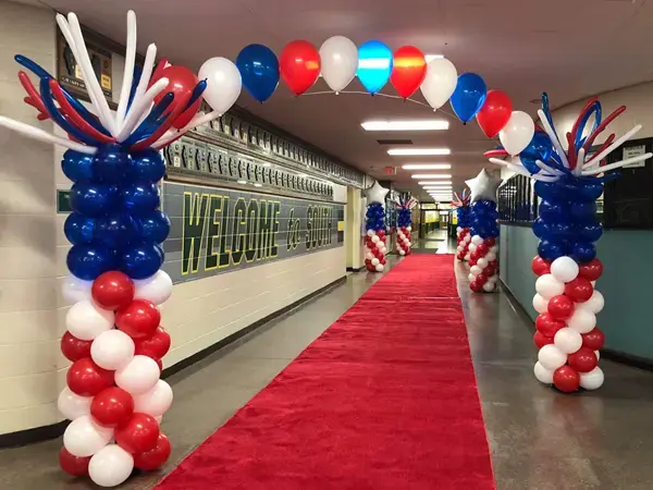 Columns with helium balloons strung between creating an arch