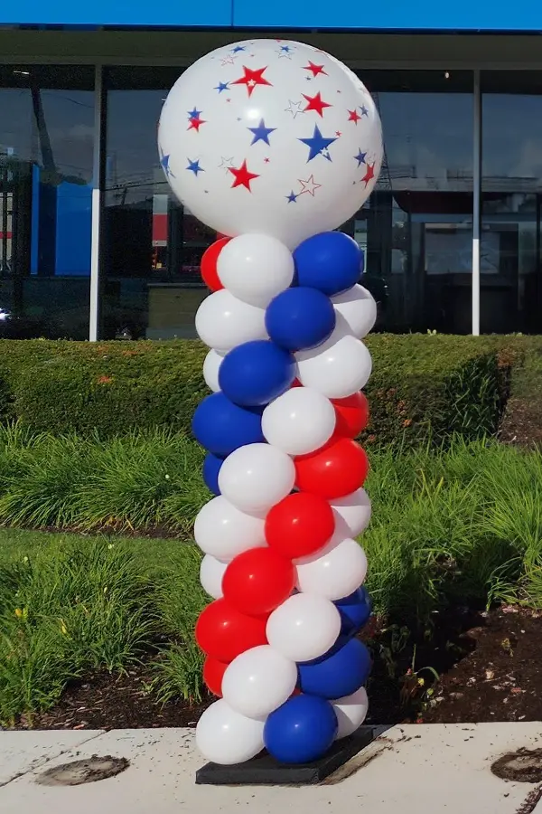 Classic balloon column in patriotic red white and blue balloons with a jumbo round balloon topper