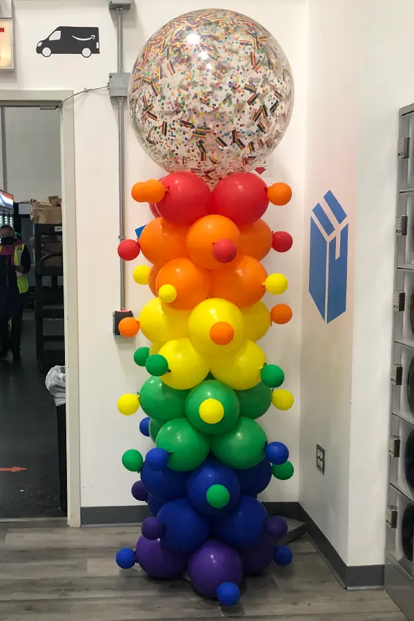8ft tall column with rainbow confetti filled topper in a fun confetti like pattern design