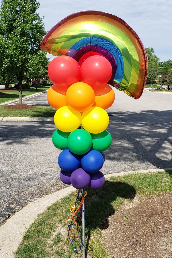 Rainbow balloon column staked into the ground as an attention getter