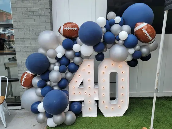 Organic balloon garland with football foils shown on Alpha-Lit numbers