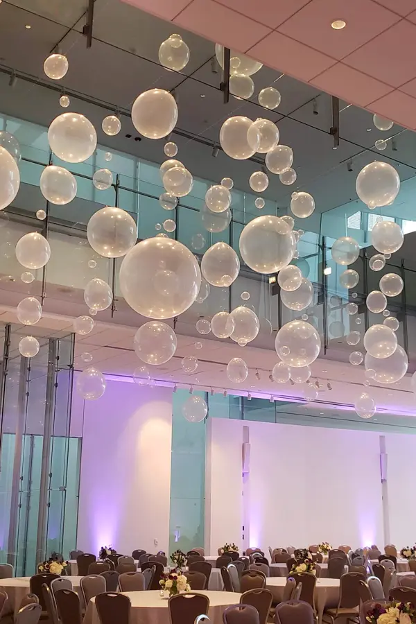 Clear balloons hanging from the ceiling creating a fun look of floating bubbles