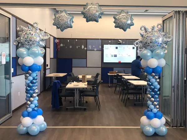 Balloon arch with roman columns on each side and foil snowflake balloons