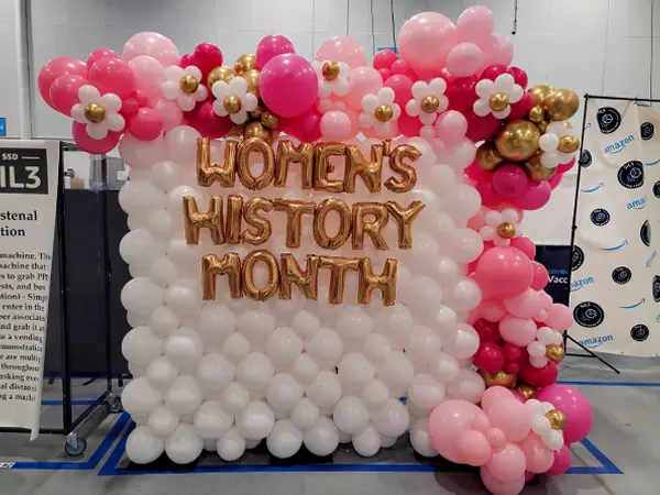 Women's History Month balloon wall backdrop with flowers